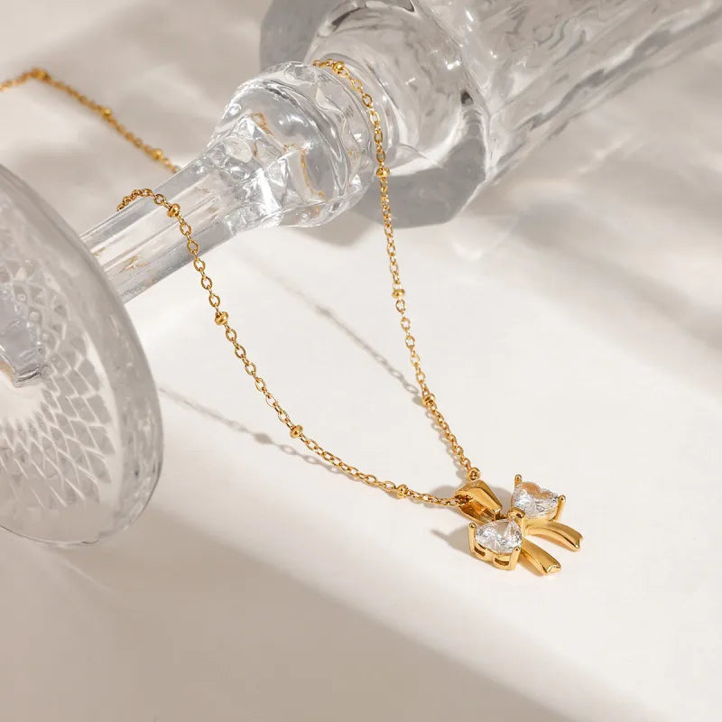 Kette mit Schleifenanhänger ⎜ Vergoldete Edelstahlkette mit funkelndem Zirkonia für feminine und elegante Looks