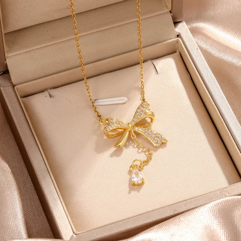 Feine Kette für Damen ⎜ Kette im Goldlook mit funkelndem Schleifenanhänger für feminine und festliche Looks