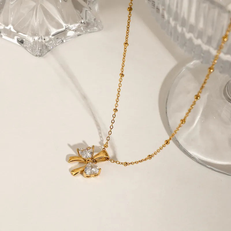 Kette mit Schleifenanhänger ⎜ Vergoldete Edelstahlkette mit funkelndem Zirkonia für feminine und elegante Looks