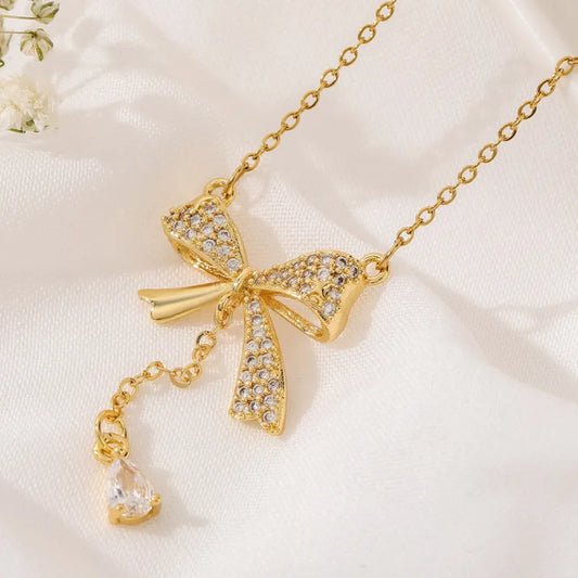 Feine Kette für Damen ⎜ Kette im Goldlook mit funkelndem Schleifenanhänger für feminine und festliche Looks