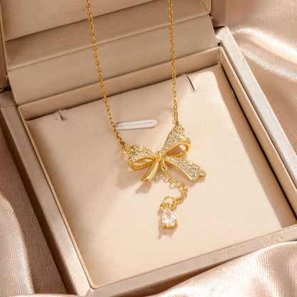 Feine Kette für Damen ⎜ Kette im Goldlook mit funkelndem Schleifenanhänger für feminine und festliche Looks